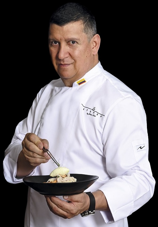 Pedro Nel, con la chaquetilla blanca de Etéreo y la bandera de Colombia, termina un plato con unas pinzas